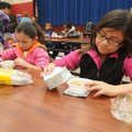 Jocelyn Martinez, 6, left, and big sister Vasti Martinez, 9, pour milk over their Frosted Flakes on ...