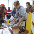 Ashley White, center, and other Heritage High School students wrap grilled chicken for sale on Satur...
