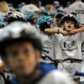 Reilly Bacoccini, 10, secures his helmet strap Monday at Tiger Athletic Complex in Bentonville durin...