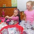 Caroline Long, 9, right, assists Hailey Prendas, 6, as she looks through possible gifts for her mom,...