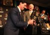 Notre Dame defensive coordinator Bob Diaco (left) tries to lift the Broyles Award trophy he won Tuesday in Little Rock while Frank Broyles, Arkansas’ former coach and athletic director, and Broyles Award executive director David Bazzel look on. Video is available at arkansasonline.com/videos.

