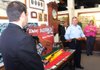 Brian Pracht (left), the University of Arkansas’ associate athletic director for marketing, listens Tuesday as Joe Murfin, vice president of marketing for Daisy Outdoor Products, talks about the new Razorback Red Ryder BB gun at a news conference in Rogers. 