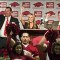 Bret Bielema (left), Jen Bielema (center) and Jeff Long lead a hog call on Wednesday. 