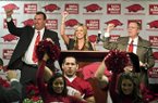 Bret Bielema (left), Jen Bielema (center) and Jeff Long lead a hog call on Wednesday.