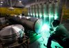 An employee of Nautic Global Group welds an end cap onto an aluminum pontoon at a factory in Elkhart, Ind., on Tuesday. Orders in October for business equipment such as machinery and communications gear rose more than previously estimated, the Commerce Department said. 