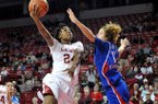NWA Media/MICHAEL WOODS --12/06/2012-- Arkansas forward Quistelle Williams drives past Kansas defender Monica Engelman to score on a fast break during the first half of Thursday night's game at Bud Walton Arena in Fayetteville.