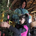 Isabelle Duran, 4, pre-K student with Springdale Public Schools, hangs a handmade ornament on a Chri...