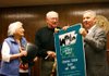 Arkansas Agriculture Secretary Butch Calhoun (right) presents a sign to Charles and Jean Oates of Pottsville on Thursday in Ozark for the Arkansas Century Farm program. 