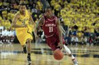 Arkansas guard BJ Young (11) drives around Michigan guard Trey Burke (3) during the first half of an NCAA college basketball game in Ann Arbor, Mich., Saturday, Dec. 8, 2012. (AP Photo/Carlos Osorio)