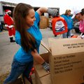 Tabitha Talburt of Garfield pulls laundry detergent Friday during the annual Sharing & Caring of Ben...