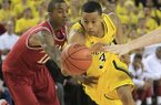 Arkansas guard BJ Young (11) reaches in and fouls Michigan guard Trey Burke (3)during the second half of an NCAA college basketball game in Ann Arbor, Mich., Saturday, Dec. 8, 2012. (AP Photo/Carlos Osorio)