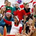 Representatives
from the Jesus Loves Me Academy (above) wave to the crowd Saturday as they pass alo...