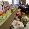 Michael Poore, Bentonville Schools superintendent, works Wednesday amid a growing pile of donated fo...