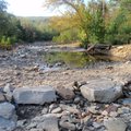 Riders sometimes cross Lee Creek in knee-deep water on the Fossil Flats Trail. The stream, seen in O...