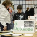 Jeremy Kalminski, 12, shows his mother Becky the research reports he and his classmates completed fo...