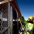 Jose Macias with Geels Paint paints the overhang on one of the dugouts for Field 6 on Thursday at th...