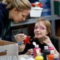 Nicole Rose, (above) left, a volunteer, lends a helping hand to Claire Ironside while she paints a C...