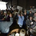 Darrell Seaman, center, holds up a metal chair Friday as auctioneer Mike Price of Price Auction Mark...