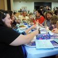 Jennifer Jackson and other members of Temple Shalom use a “shamash” or “helper candle” to light the ...