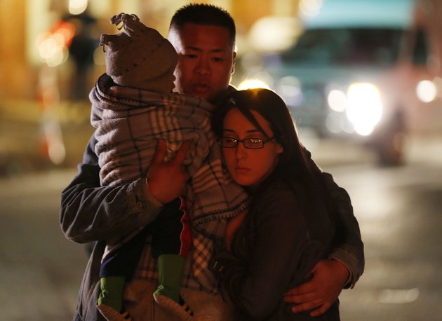 johnny-nhatavong-center-of-new-haven-conn-embraces-his-wife-melennie-rizek-right-and-their-11-month-old-son-kenzo-jung-while-stopping-at-a-makeshift-memorial-near-the-place-where-a-day-earlier-a-gunman-opened-fire-inside-of-an-elementary-school-saturday-dec-15-2012-in-newtown-conn-the-man-who-died-from-a-self-inflicted-wound-allegedly-killed-his-mother-at-their-home-and-then-opened-fire-friday-inside-the-sandy-hook-elementary-school-massacring-26-people-including-20-children