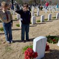 Noah Toto, left, age 10, and Eddie Hunter, age 10, both from Rogers, salute after putting a wreath o...