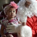 Winter Hill, 9 months, looks to her mother Adaline as she has her photo taken Saturday with Santa Cl...