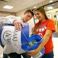 Stokes Wenzler, Deca vice president, dumps donated money into the bucket Friday held by club preside...