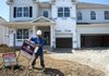 A construction worker places a sign in the front yard of a house in the Fox Glen subdivision of Pickerington, Ohio, in August. The National Association of Home Builders/Wells Fargo builder sentiment index this month said builders reported a good market for newly built homes. 