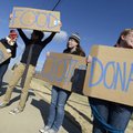 Samantha Farley, from left, 16, Keaton Duersch, 16, Katie Wilson, 17, and Emma Hackett, 17, wave sig...