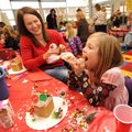 Lori Massey, left, laughs Thursday as her 7-year-old daughter Maggie squirts icing into her mouth wh...