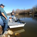 Mike McBride, manager of Lake Sequoyah in Fayetteville, laughs Friday while helping longtime fisherm...