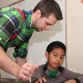 Kyle Queen, fourth-grade teacher at Bonnie Grimes Elementary School, helps Allan Alfaro with compute...