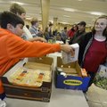 Matthew White, 10, (above left) hands Teresa Blackwood a package of rolls Saturday for her food box ...