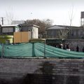 Afghans walk past by a gate of the Kabul police headquarters, where an American advisor was killed i...