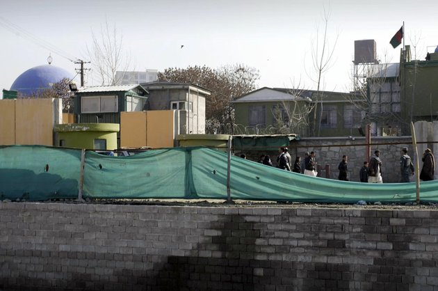 afghans-walk-past-by-a-gate-of-the-kabul-police-headquarters-where-an-american-advisor-was-killed-in-kabul-afghanistan-monday-dec-24-2012-an-afghan-policewoman-killed-an-american-adviser-at-the-kabul-police-headquarters-on-monday-a-senior-afghan-police-official-said