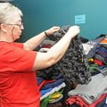 Willa Lawson sorts through hoodies and sweatshirts Monday during the fourth annual Miracle on 14th S...