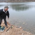 Kenneth Carmical checks his fishing rods Tuesday while fishing for trout at Lake Atalanta in Rogers....