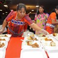 Linda Morris, left, from Marshallese United Church of Christ, adds bread to a tray filled with rice ...