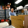 Adam Miller sends a CountryOutfitter.com shipment Dec. 7 down the rollers in the warehouse of Acumen...