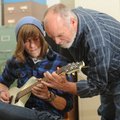 Halen Auxier, an 18-year-old senior at Fayetteville High School, left, gets a hand from guitar instr...