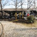 Representatives from Farmington, Prairie Grove and Lincoln fire departments work Wednesday to finish...