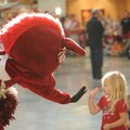 Lexa Smith, 3, of Fayetteville gets a high-five from Sue E., one of the University of Arkansas masco...