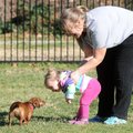Renee Mendez of Bentonville, right, holds her daughter Sofia, 16 months, as Sofia bends down for a k...