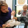 First grader Jack Taylor, 6, right, reacts as his mother, Brooke Taylor, paints the bottom of his fo...