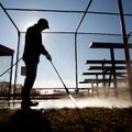 Casey Bridges with City of Bentonville Parks & Recreation pressure washes the seating area for one o...