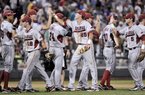 Arkansas players, including Tim Carver (18), Dominic Ficociello (25) and Matt Reynolds (5), exchange high-fives after beating South Carolina 2-1 in an NCAA College World Series baseball game in Omaha, Neb., Monday, June 18, 2012. (AP Photo/Ted Kirk)