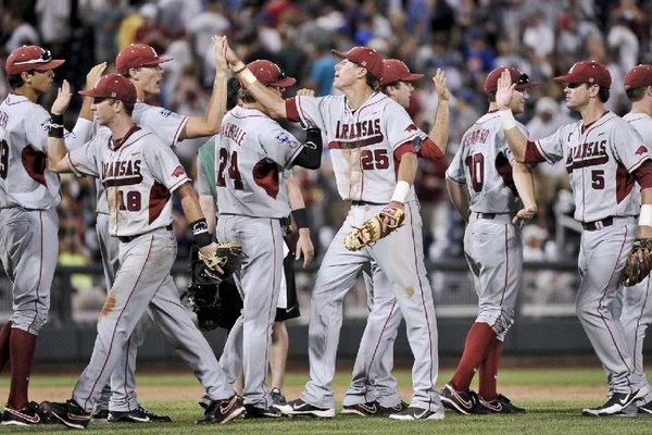Arkansas players, including Tim Carver (18), Dominic Ficociello (25) and Matt Reynolds (5), exchange high-fives after beating South Carolina 2-1 in an NCAA College World Series baseball game in Omaha, Neb., Monday, June 18, 2012. (AP Photo/Ted Kirk)