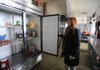 Georgia Mjartan, executive director of the Our House shelter in Little Rock, looks at what food remains Thursday after an extended power failure led to spoilage. 
