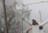 Fog blankets utility workers Friday as they repair broken power lines along Cantrell Road in Little Rock. Tree limbs weighed down from ice and snow Tuesday night snapped power lines across the state and initially left more than 200,000 electric customers without power.

