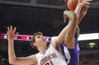 University of Arkansas forward Hunter Mickelson and Northwestern State forward DeQuan Hicks fight for a rebound the first half of Saturday night's game. Mickelson and BJ Young both finished with a 13 rebounds, a career high for each player.
